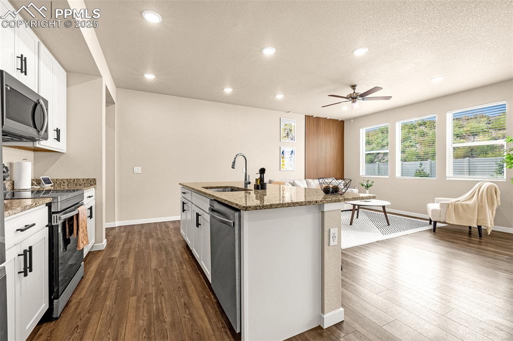 Image 8 of 35: Kitchen featuring white cabinets, stainless steel appliances, a textured ce
