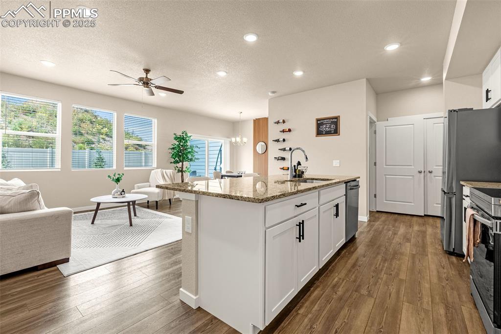 Image 9 of 35: Kitchen featuring light stone countertops, white cabinets, a chandelier, re