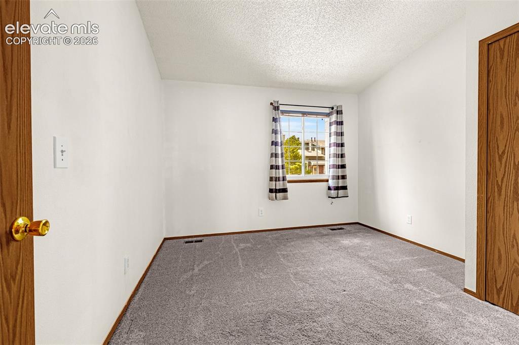 Image 12 of 32: Neutral-toned walls complement the gray carpeting