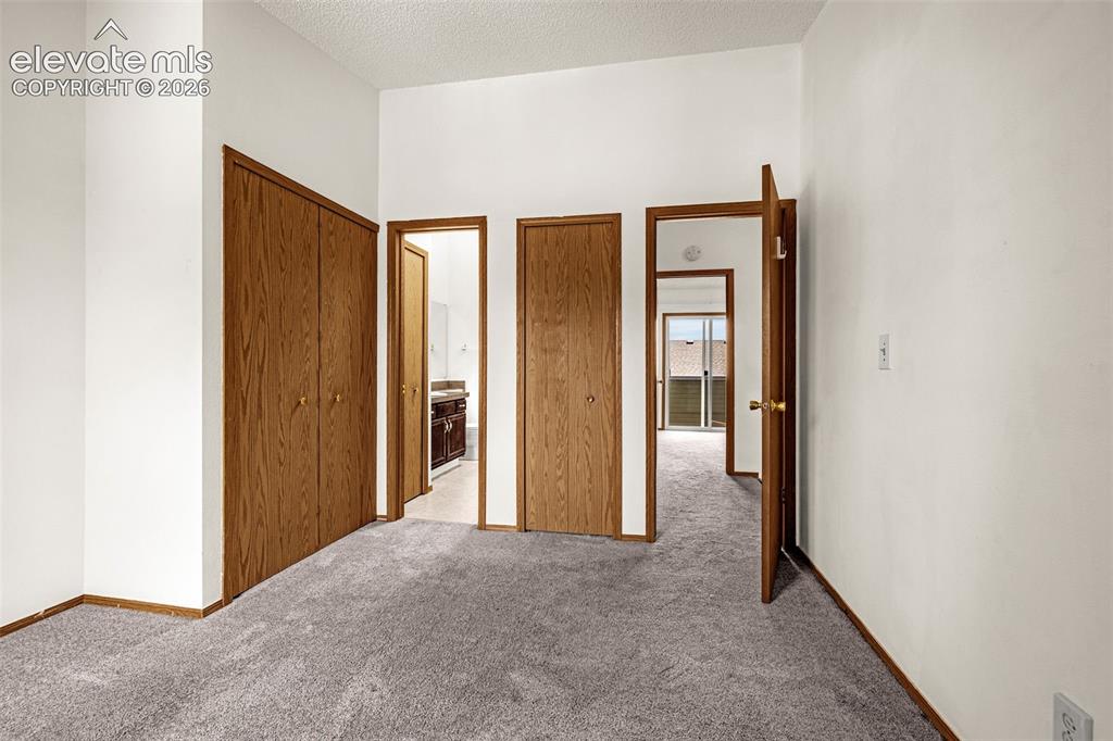 Image 13 of 32: Neutral wall colors, wood-finish doors, and gray carpeting