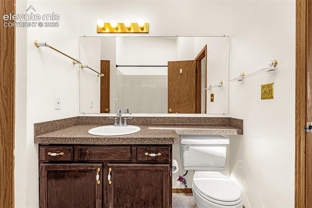 Image 16 of 32: Bathroom vanity with a dark wood-finish cabinet and integrated sink, comple