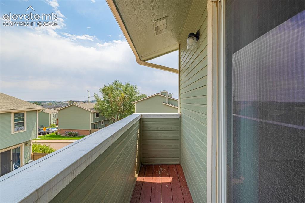 Image 19 of 32: Balcony with horizontal siding, wood-finish flooring, and exterior lighting