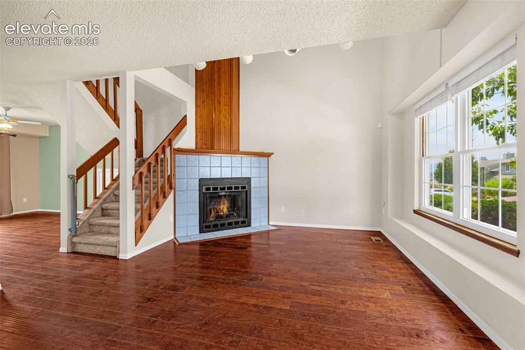 Image 3 of 32: Wood-finish flooring, staircase with carpeted treads and wood railings, fir