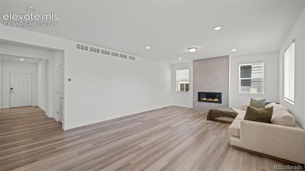 Image 14 of 38: Open concept living space featuring wood-finish flooring, a modern fireplac