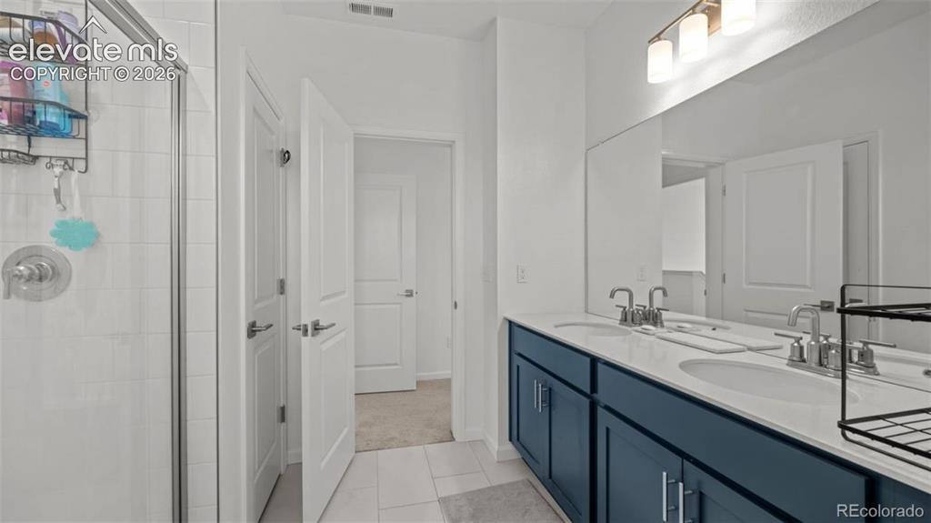 Image 18 of 38: Dual vanity with integrated sinks, brushed nickel fixtures, and a spacious 