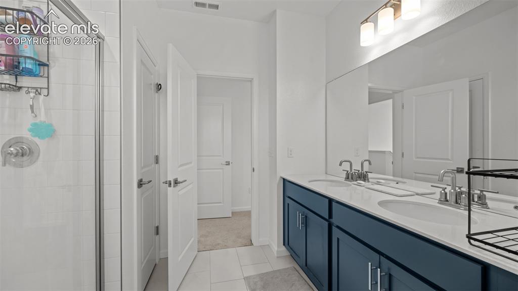 Image 19 of 37: Dual vanity with undermount sinks, chrome fixtures, and a large mirror
