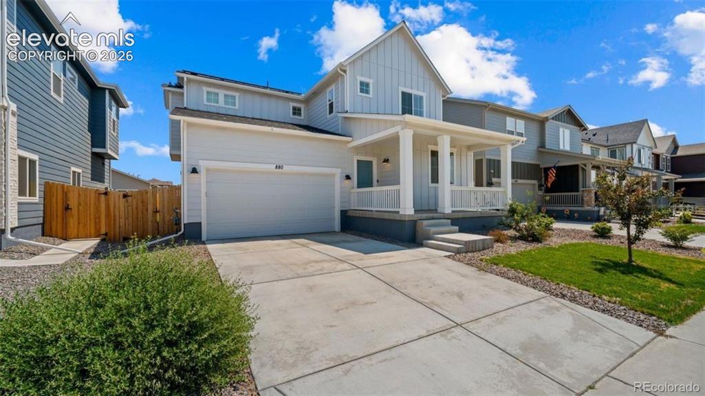 Image 2 of 38: Two-story exterior with a covered front porch, integrated garage, concrete 