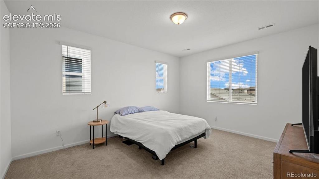 Image 21 of 38: Neutral carpeted flooring, white painted walls, and a semi-flush mount ceil