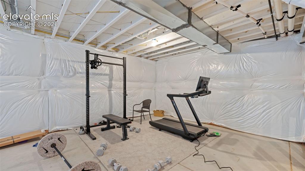Image 25 of 37: Unfinished basement with exposed ceiling joists and ductwork, featuring whi