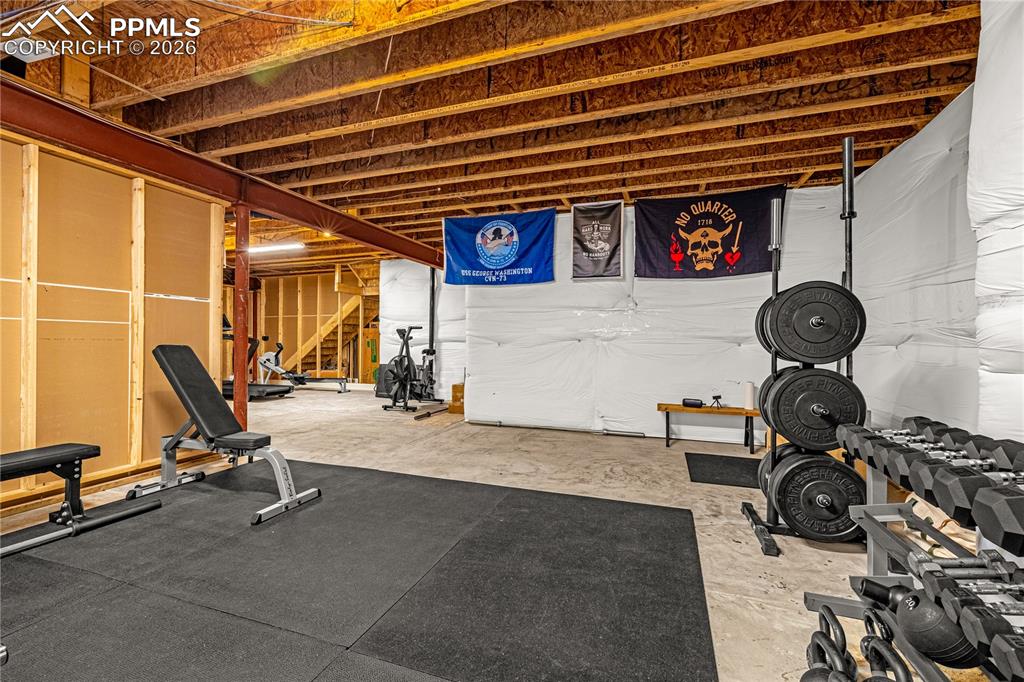 Image 26 of 37: Living area with dark wood-style floors, a ceiling fan, a tiled fireplace, 