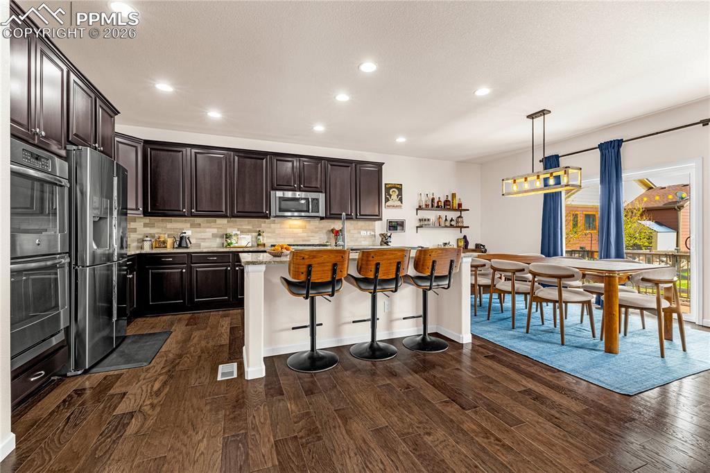 Image 9 of 37: Kitchen with a breakfast bar area, dark wood finish cabinets, a center isla