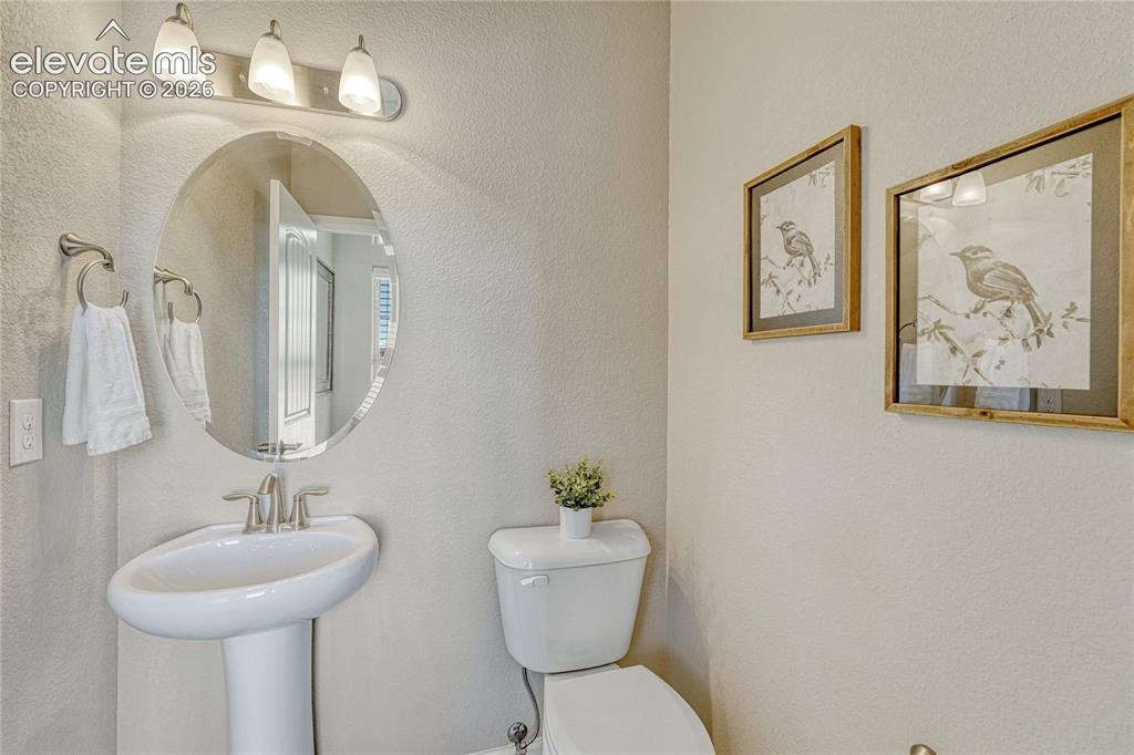 Image 15 of 47: A conveniently located half bathroom near the entry provides functionality