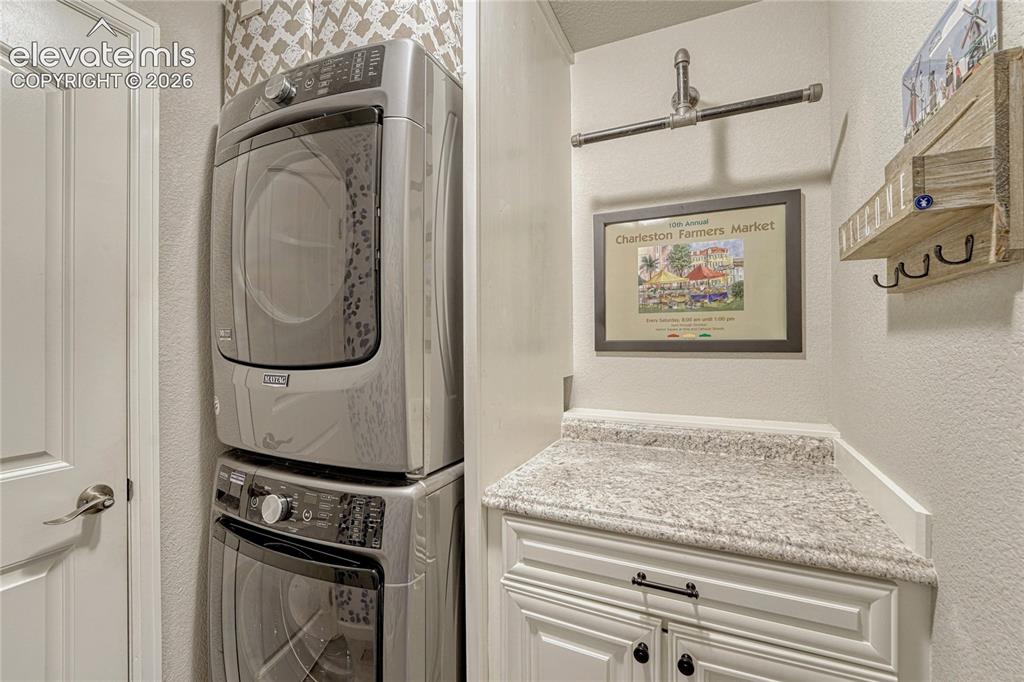 Image 16 of 47: The dedicated laundry room adds everyday convenience with a stacked Maytag