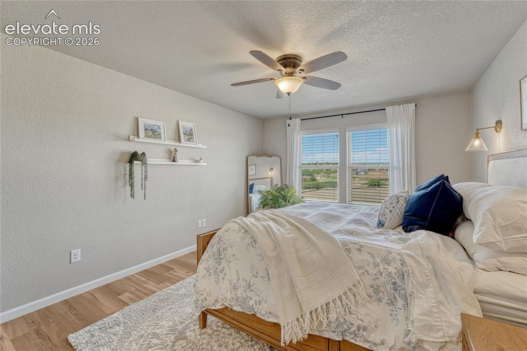 Image 19 of 47: The primary bedroom provides a calming retreat with large windows showcasin