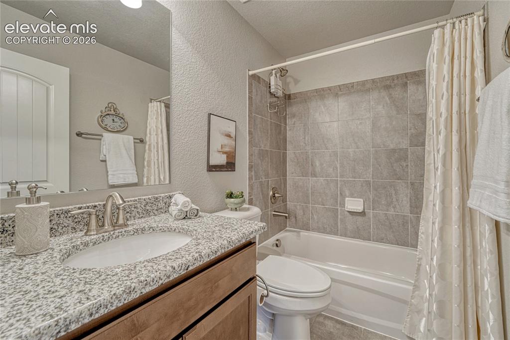 Image 29 of 47: The basement bathroom adds convenience with a granite vanity, neutral finis