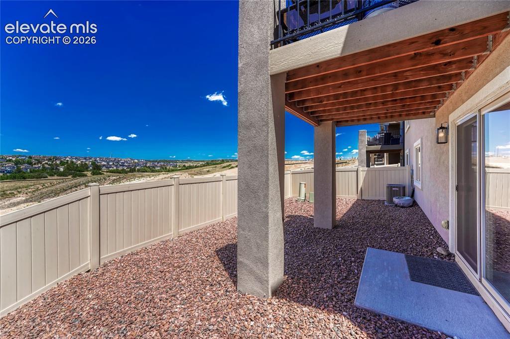 Image 37 of 47: The covered patio offers a private outdoor retreat with low-maintenance lan