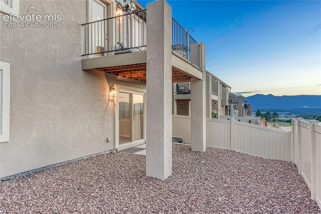 Image 39 of 47: The outdoor spaces combine a covered patio and elevated composite balcony t