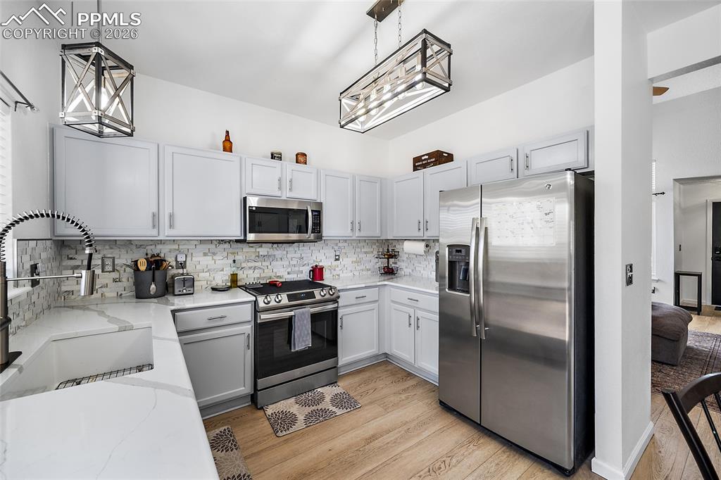 Image 12 of 46: Modern kitchen featuring light gray cabinetry, stainless steel appliances, 