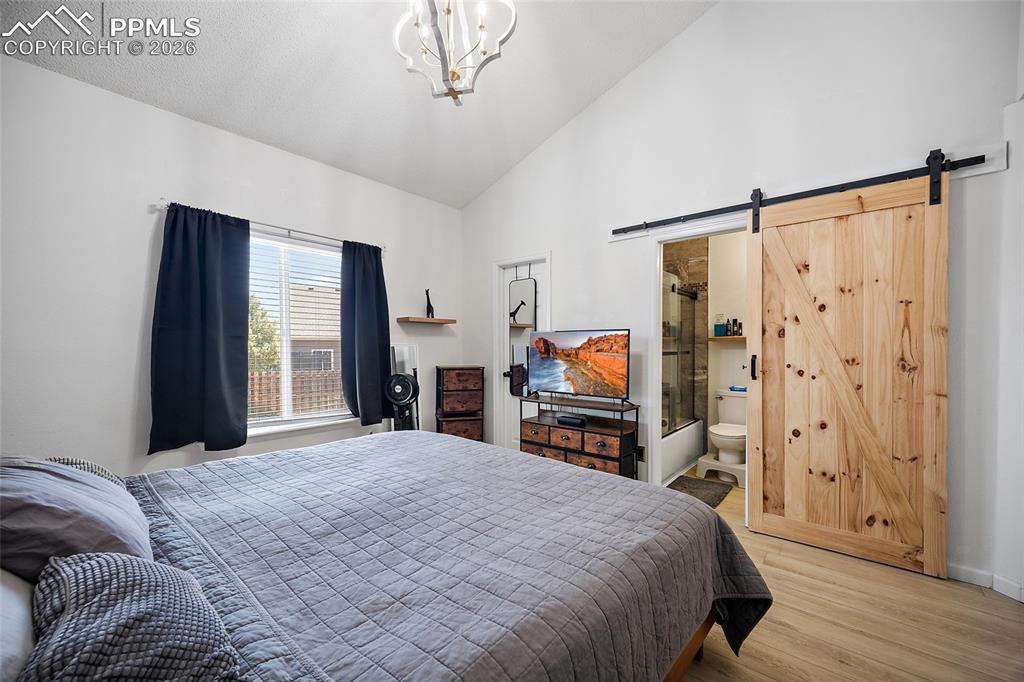 Image 18 of 46: Vaulted ceilings frame this living space featuring wood-finish flooring and
