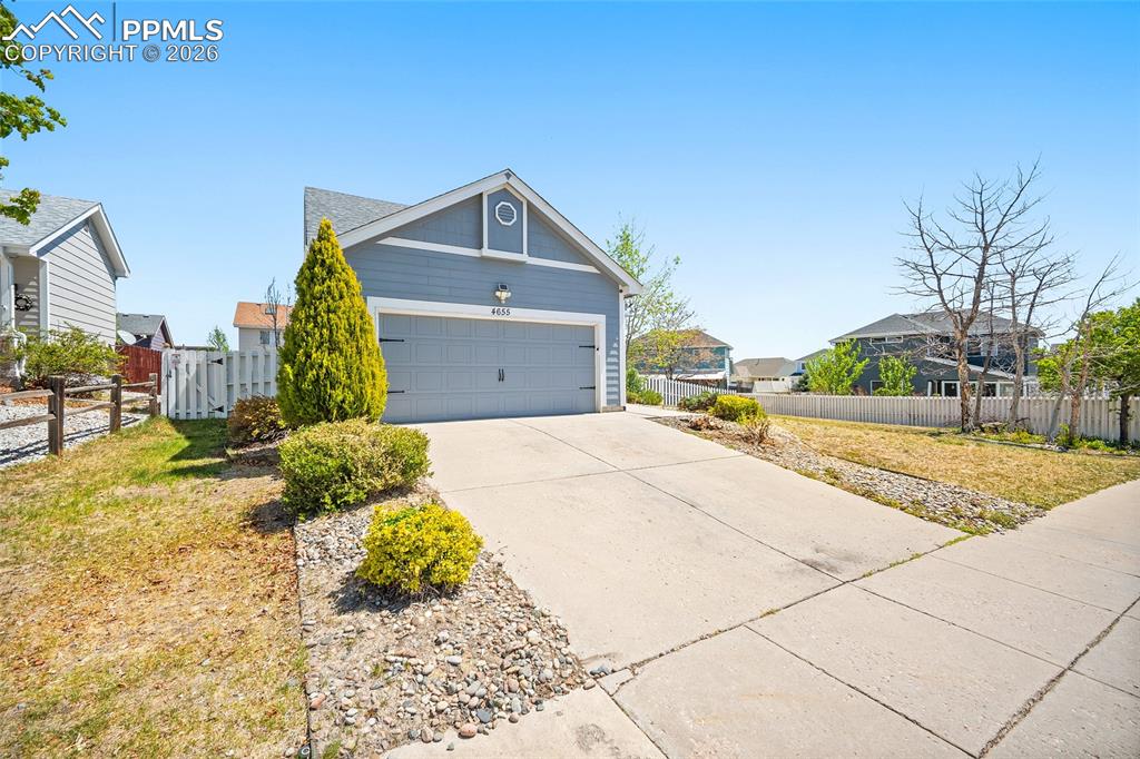 Image 2 of 46: Siding exterior with an attached garage, concrete driveway, and front lands