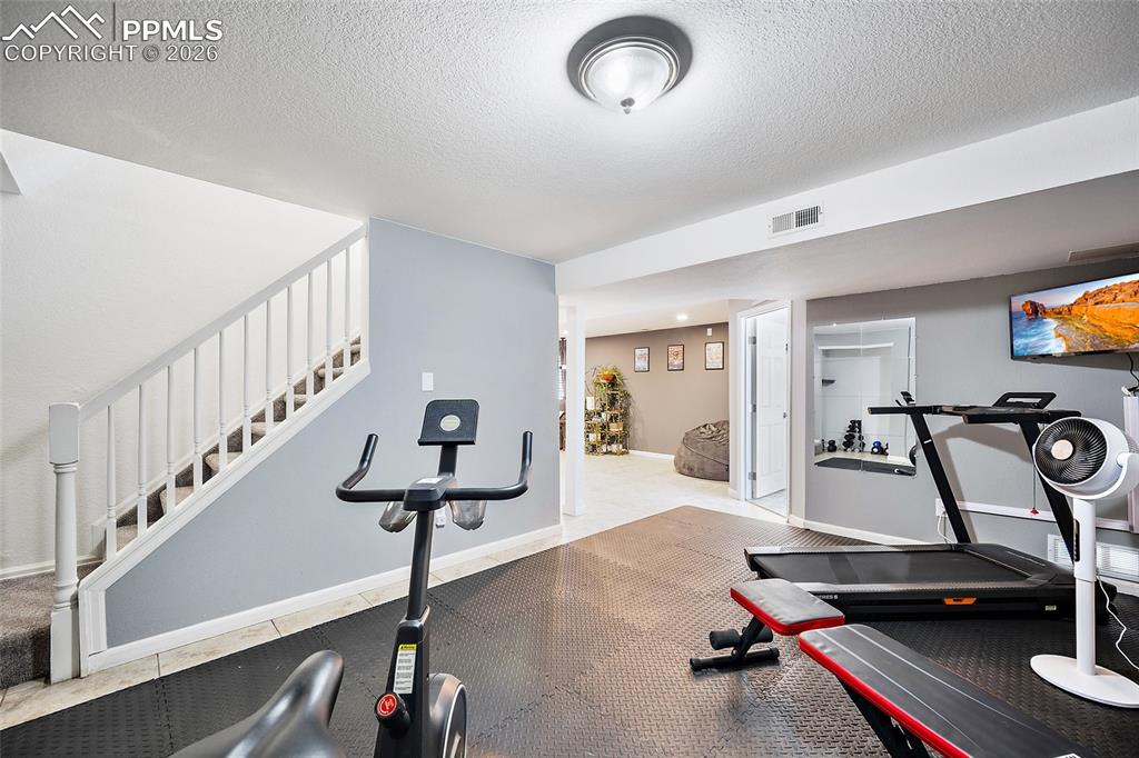 Image 25 of 46: Lower level featuring a staircase with white balusters, recessed lighting, 