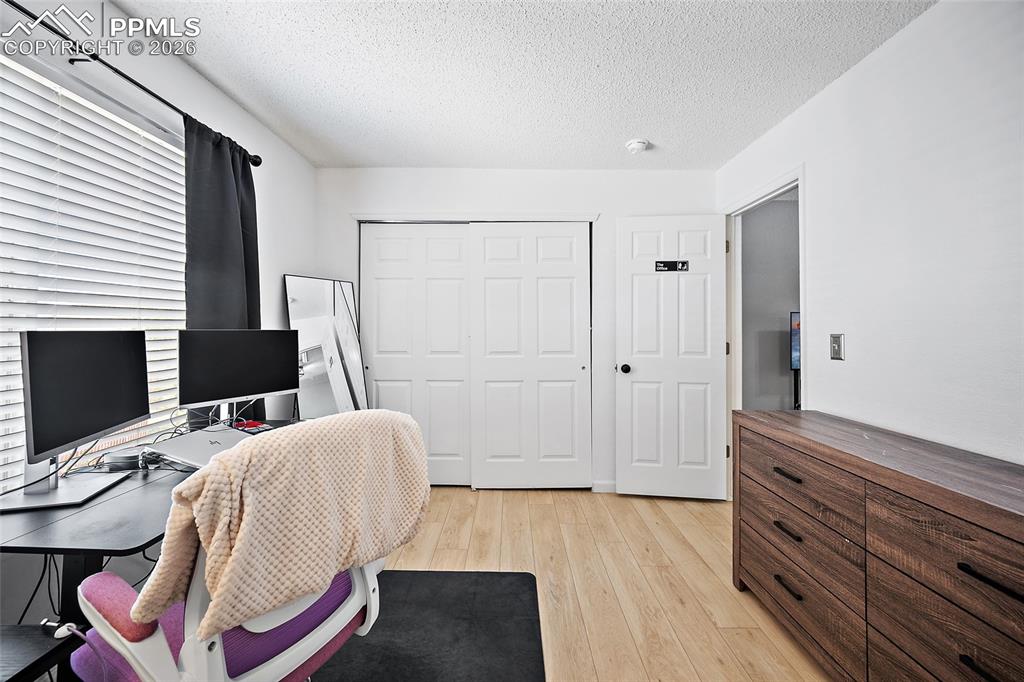 Image 38 of 46: Room featuring light wood-finish flooring, white walls, and a textured whit