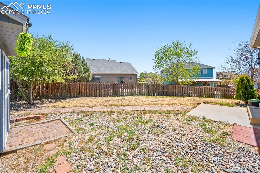Image 43 of 46: Expansive rear yard featuring a wood privacy fence, mature trees, a concret