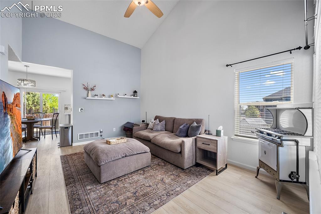Image 6 of 46: Living space featuring vaulted ceilings, wood-finish flooring, and a ceilin