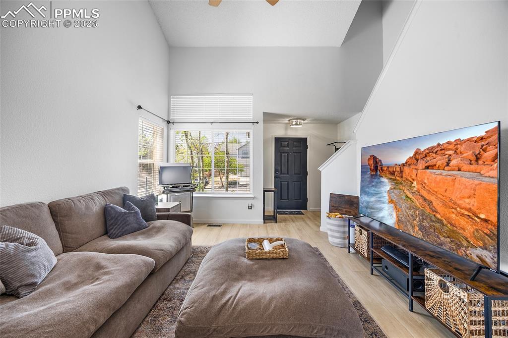 Image 8 of 46: Bright living space featuring vaulted ceilings, a large window with horizon