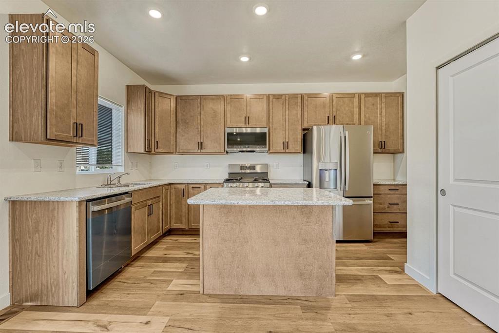 Image 10 of 50: Kitchen features granite counters, bar-top island, and 42in extended height