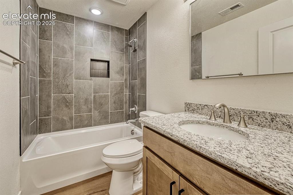 Image 41 of 50: Full bathroom in the basement features granite counters and undermount sink