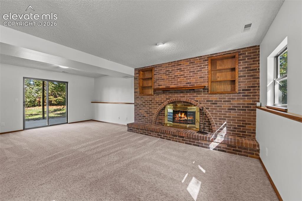 Image 12 of 22: Lower level family room walks out to concrete patio and shed