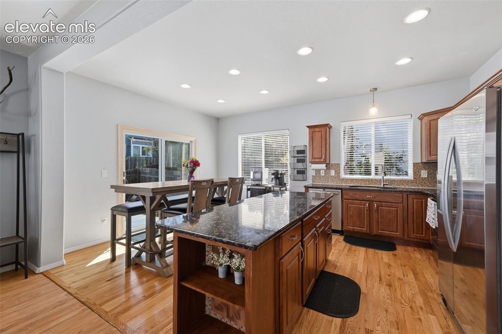 Image 12 of 35: Kitchen featuring wood-finish flooring, recessed lighting, and a center isl