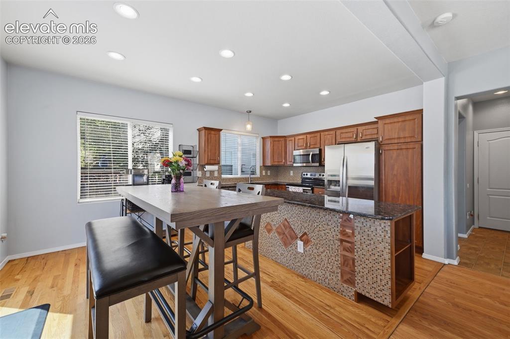 Image 13 of 35: Kitchen featuring wood-finish flooring, recessed lighting, and a kitchen is