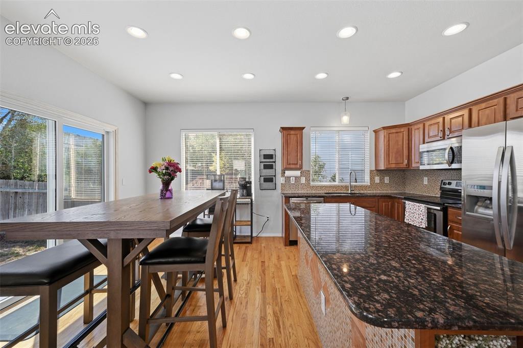 Image 14 of 35: Kitchen featuring wood-finish flooring, recessed lighting, wood cabinetry, 