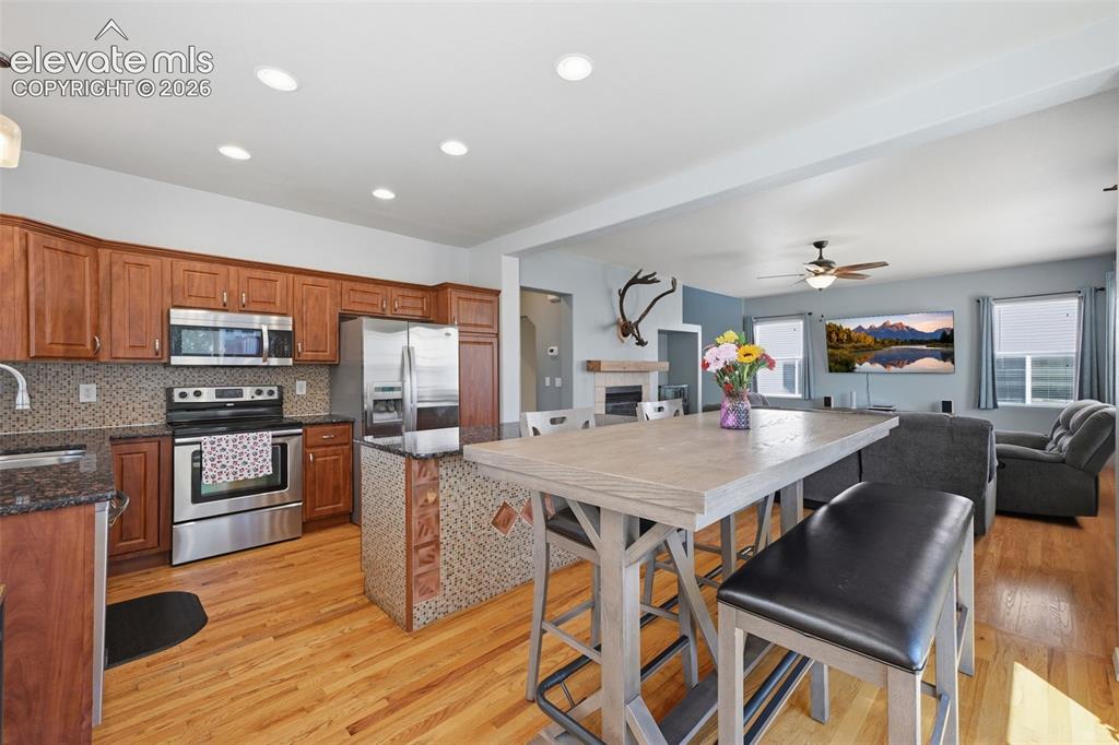 Image 15 of 35: Wood-finish flooring throughout, with a kitchen featuring wood cabinetry, s