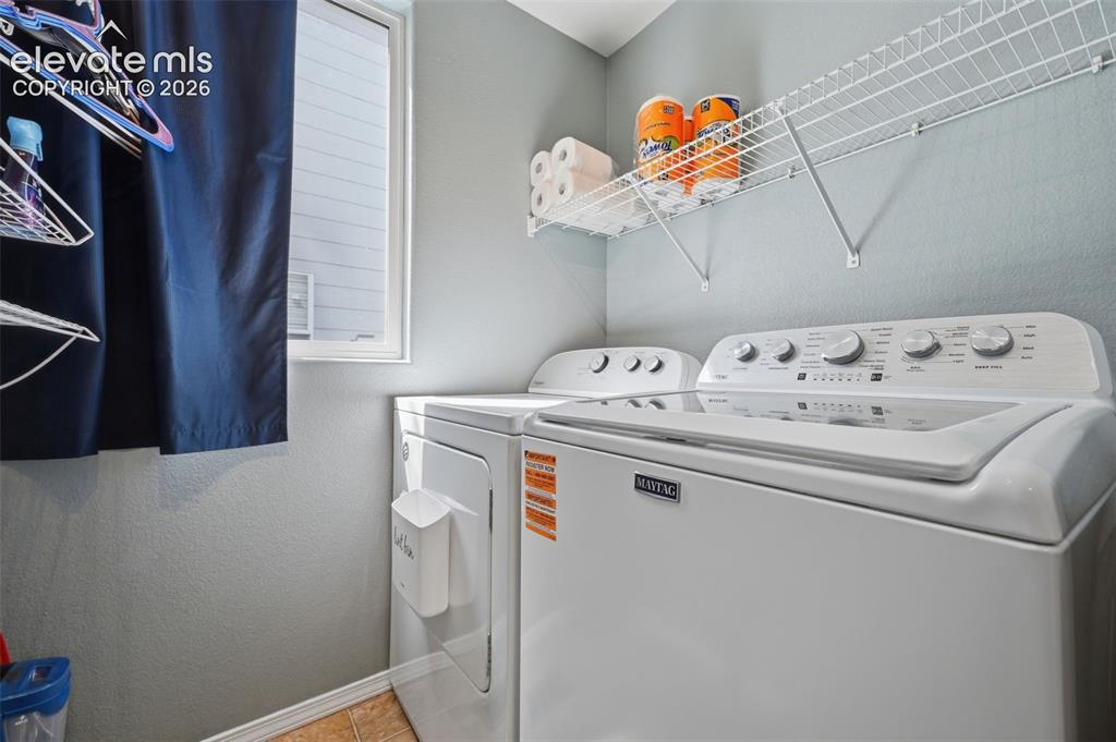 Image 18 of 35: Laundry area featuring a window, white wire shelving, and light gray walls