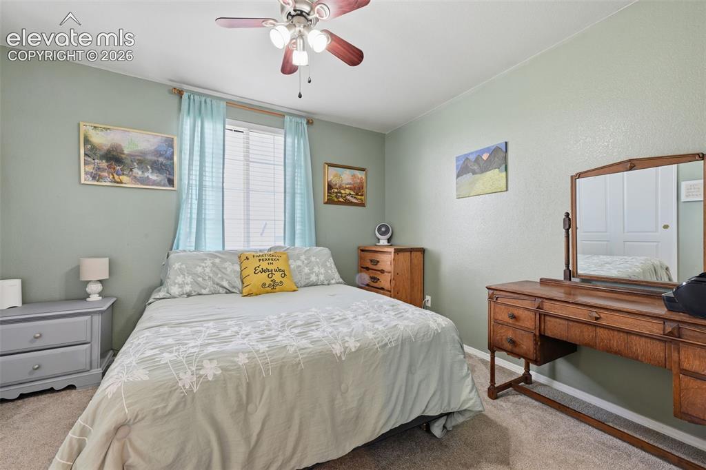 Image 27 of 35: Ceiling fan with light fixture, window with blinds, carpeted flooring