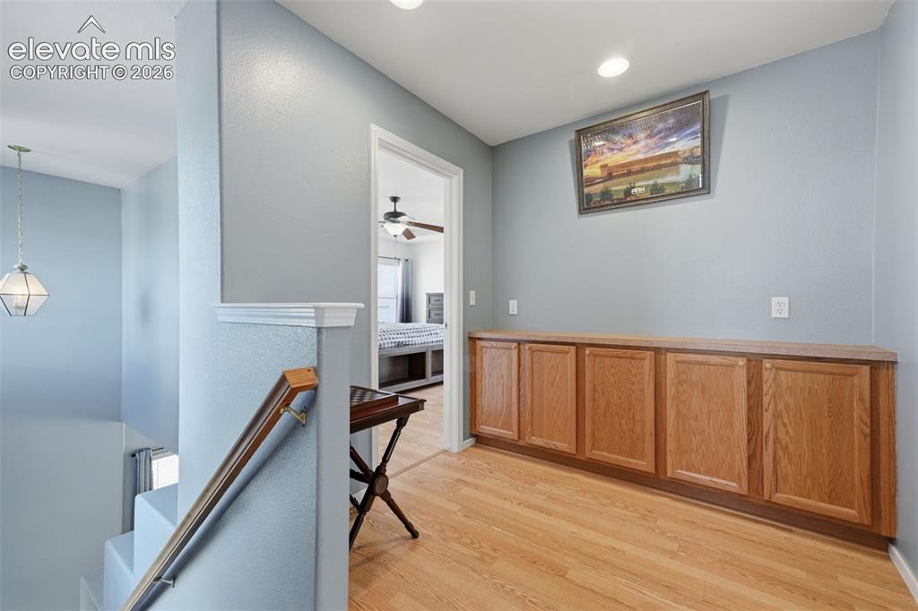 Image 29 of 35: Wood-finish flooring, built-in wooden cabinetry, recessed lighting, and a s