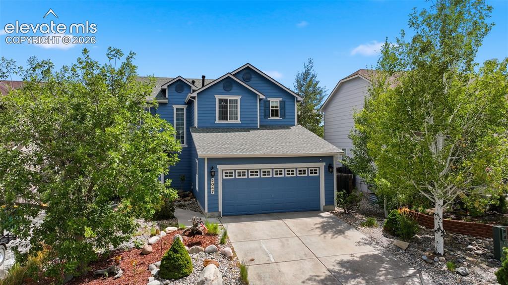 Image 3 of 35: Blue exterior with white trim, attached garage, concrete driveway, and a la