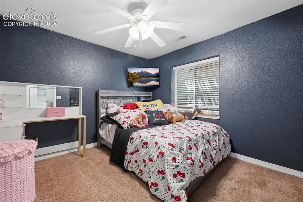 Image 33 of 35: Textured walls, recessed window with blinds, ceiling fan, carpet flooring,