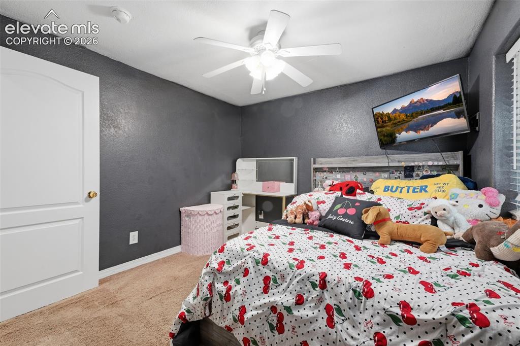 Image 34 of 35: White paneled door with brass hardware, ceiling fan with light fixture, car