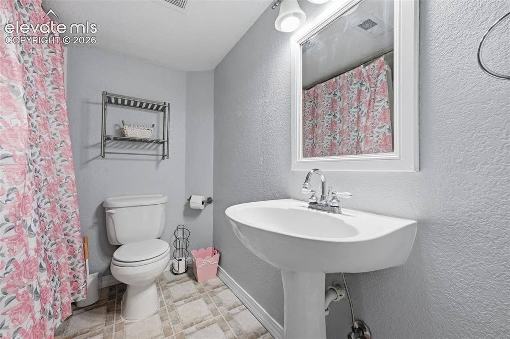 Image 35 of 35: Pedestal sink with chrome faucet, framed vanity mirror, overhead vanity lig