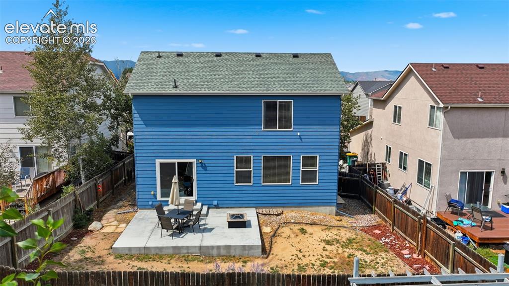 Image 4 of 35: Blue siding exterior with a green shingle roof