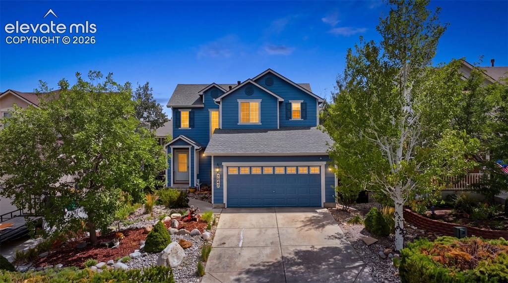 Image 6 of 35: Two-story residence featuring a two-car garage, mature landscaping, and a c