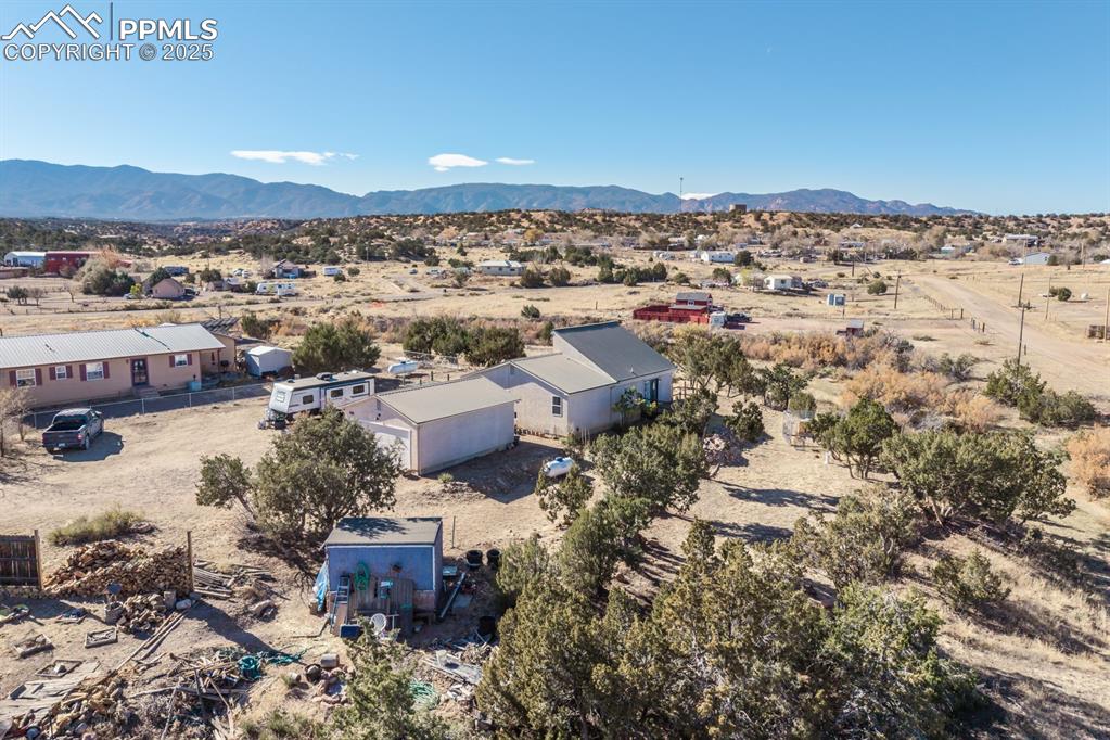 Image 10 of 50: Aerial view of sparsely populated area featuring mountains and a desert lan