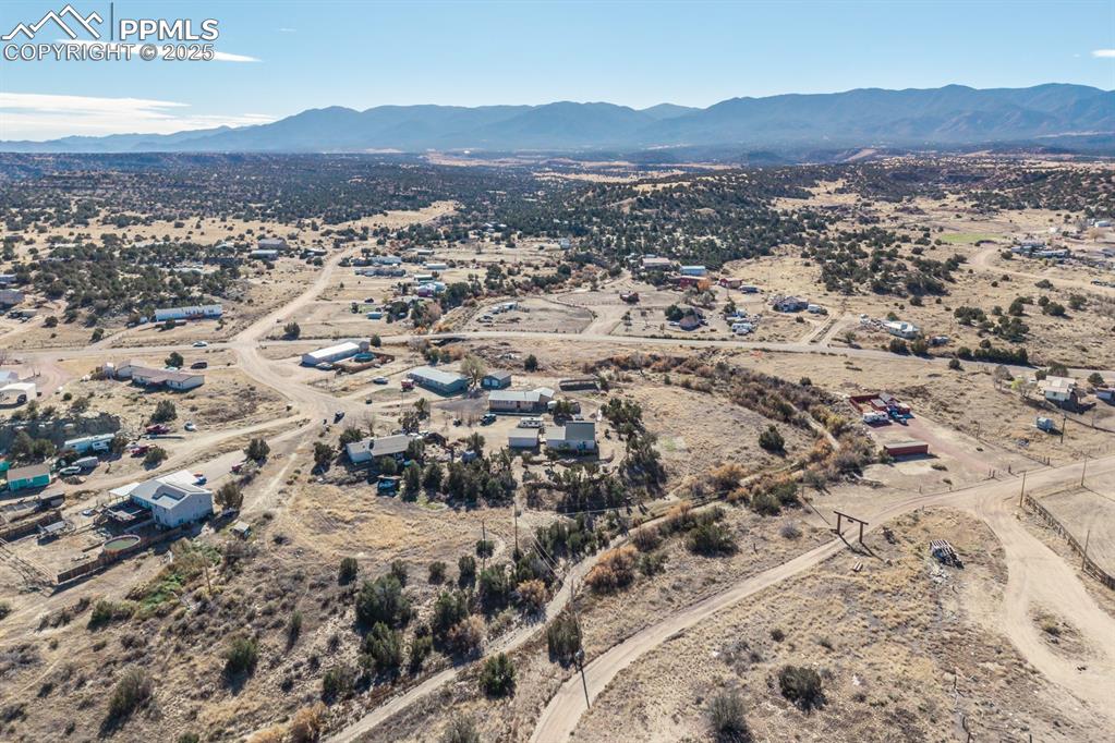 Image 14 of 50: Aerial view of sparsely populated area featuring a mountainous background