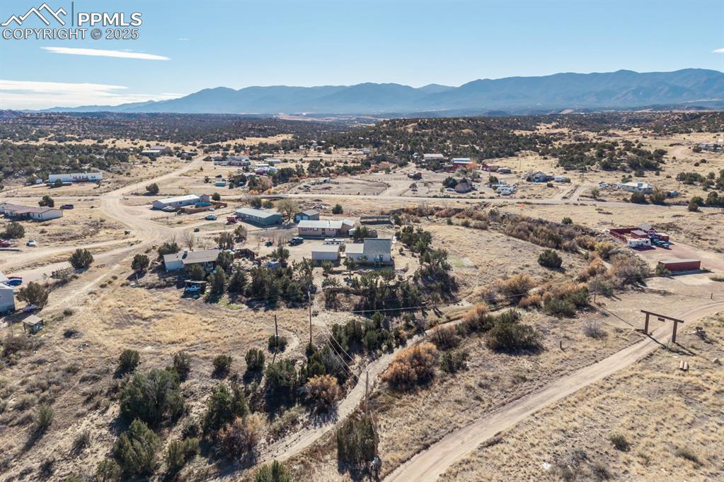 Image 15 of 50: Aerial view of sparsely populated area with a desert landscape and a mounta