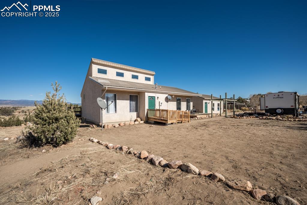 Image 31 of 50: Back of house featuring a deck and a metal roof
