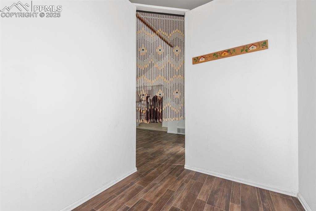 Image 38 of 50: Corridor featuring baseboards and dark wood-style flooring